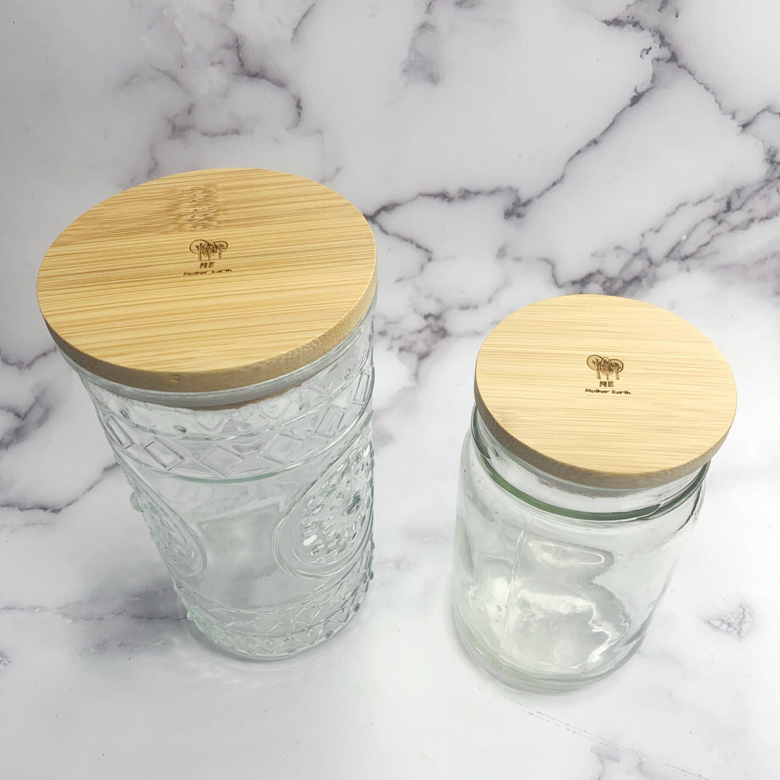 ME Mother Earth Standard Jar Lid on Glass Jar on Right, Shown with Wide Jar Lid on Glass Jar on Left for Size Comparison. 