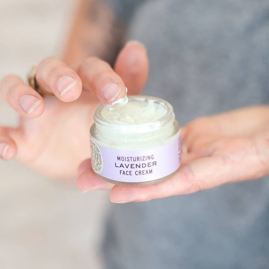 Good Flower Farm Organic Lavender Moisturizing Face Cream Being Held With Finger Dipped In Cream.
