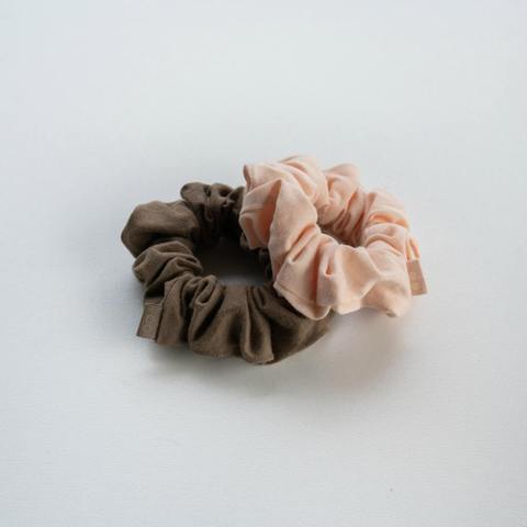 Kooshoo Organic, Plastic-Free Hair Scrunchies. Two Shown, In Soft Pink And Warm Gray Colors.