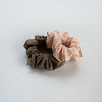 Kooshoo Organic, Plastic-Free Hair Scrunchies. Two Shown, In Soft Pink And Warm Gray Colors.